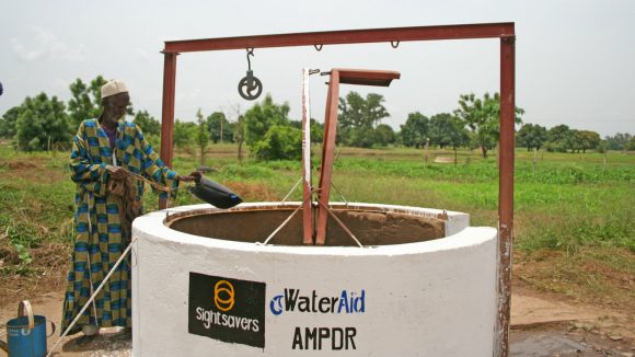 A man gathers fresh water at a new well.