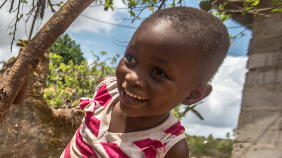 Asha smiles outside her home following her cataract operation.