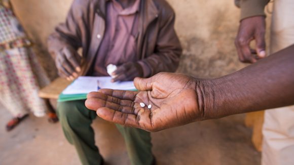 A hand holds medication used to treat NTDs.