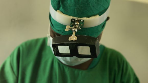 A trachoma surgeon wearing green scrubs.