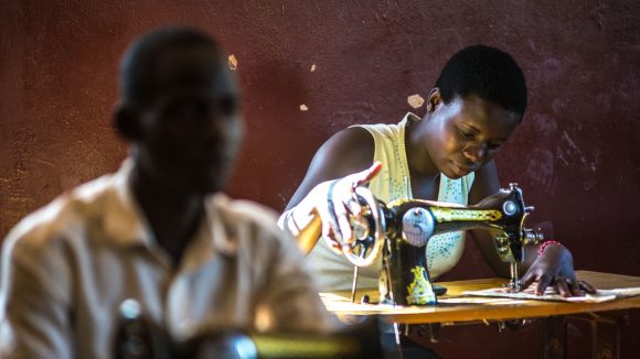 A young woman working at a sewing machine.