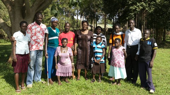 Edith stands outside with a group of students from the Connecting the Dots programme.