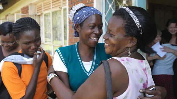 Two women embracing and smiling.
