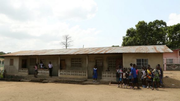 Children wait to start lessons outside a school in Sierra Leone.