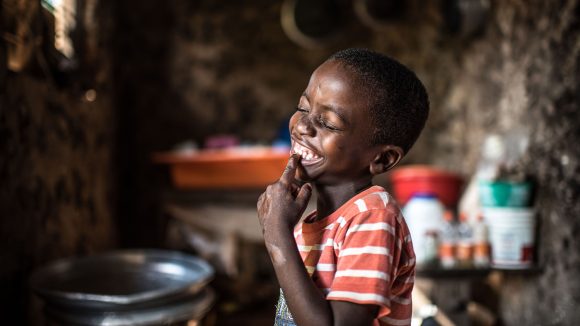 Fahad smiling in his home.