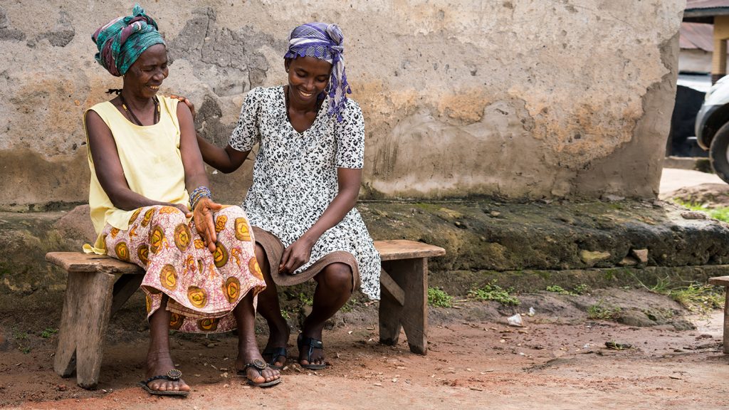 Haja and her mother Kadiatu laugh with each other.