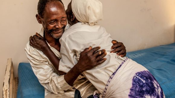 Winesi a 69 year old man, hugs his wife and smiles after his cataract operation.