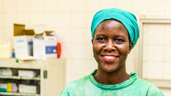 Gladys Atoo in her Doctor's uniform, smiles at the camera