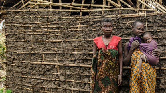 Aluna, Mayasa and Bibi in front of their mud house