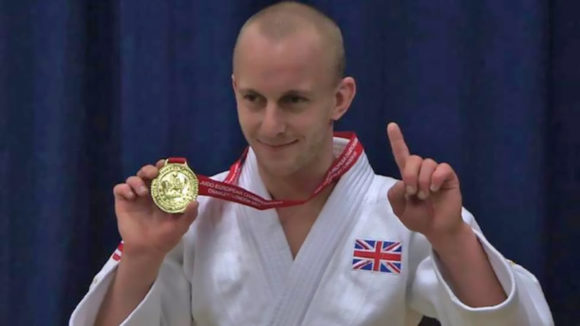 ben quilter holding a medal.