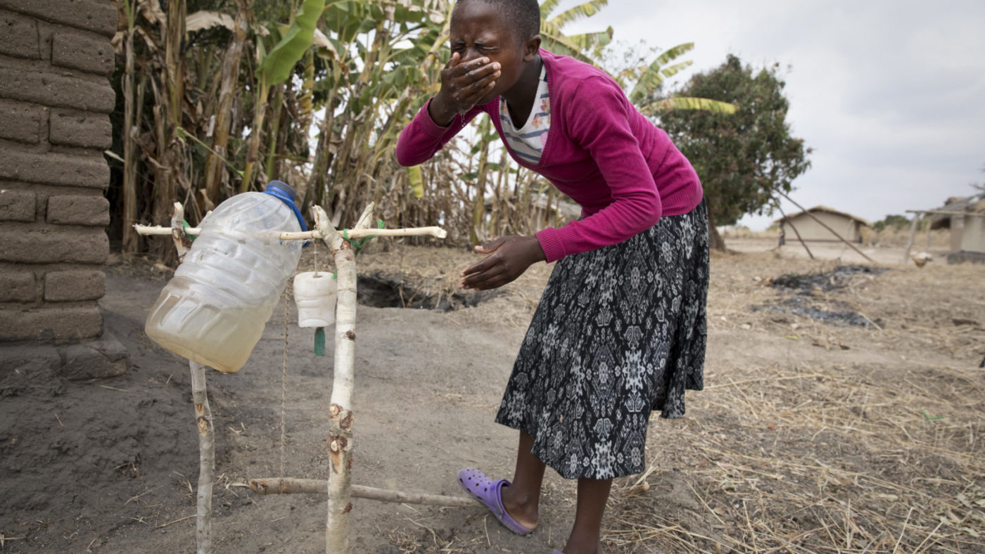 Schoolgirl and trachoma champion Safira Mwale shows how to wash her face with a tippy tap by her home near Kasungu in Malawi, August 29, 2018.