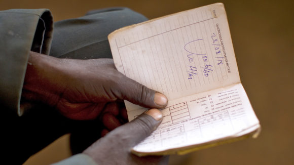 A close-up of a man holding some paperwork.