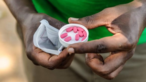 Hands hold a cap full of treatment for neglected tropical diseases.