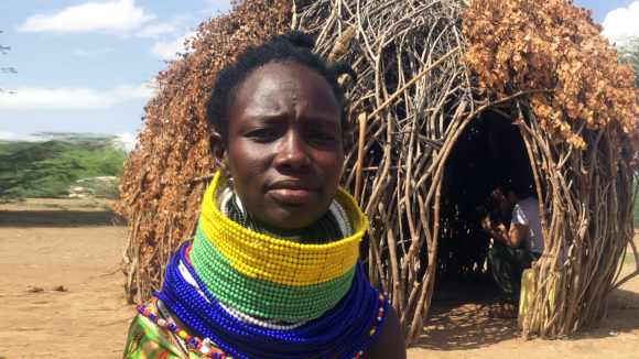 A lady sits outside in rural Kenya.