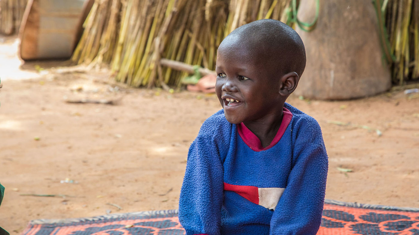 With his sight restored, Muzi sits with a smile on his face in his village in Nigeria.