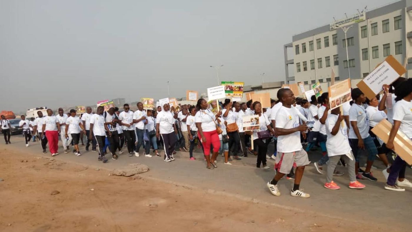 People march in the streets carrying placards.