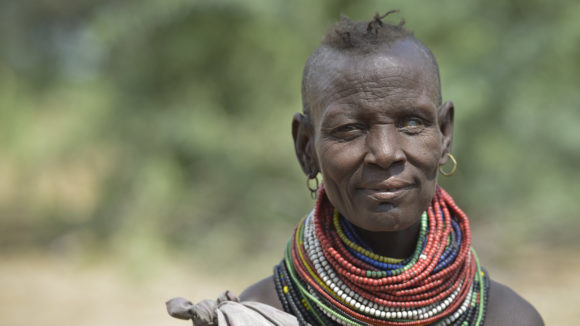 A woman dressed in traditional clothing poses for the camera. she is blind in her left eye.