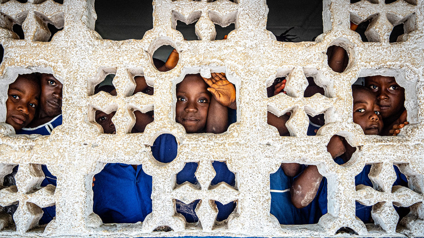 Children look through a window.