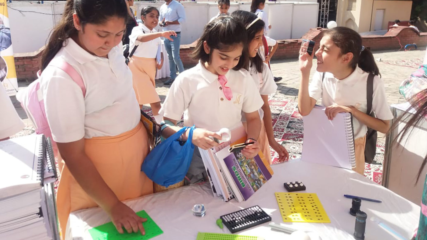 A group of children look at accessible reading materials.