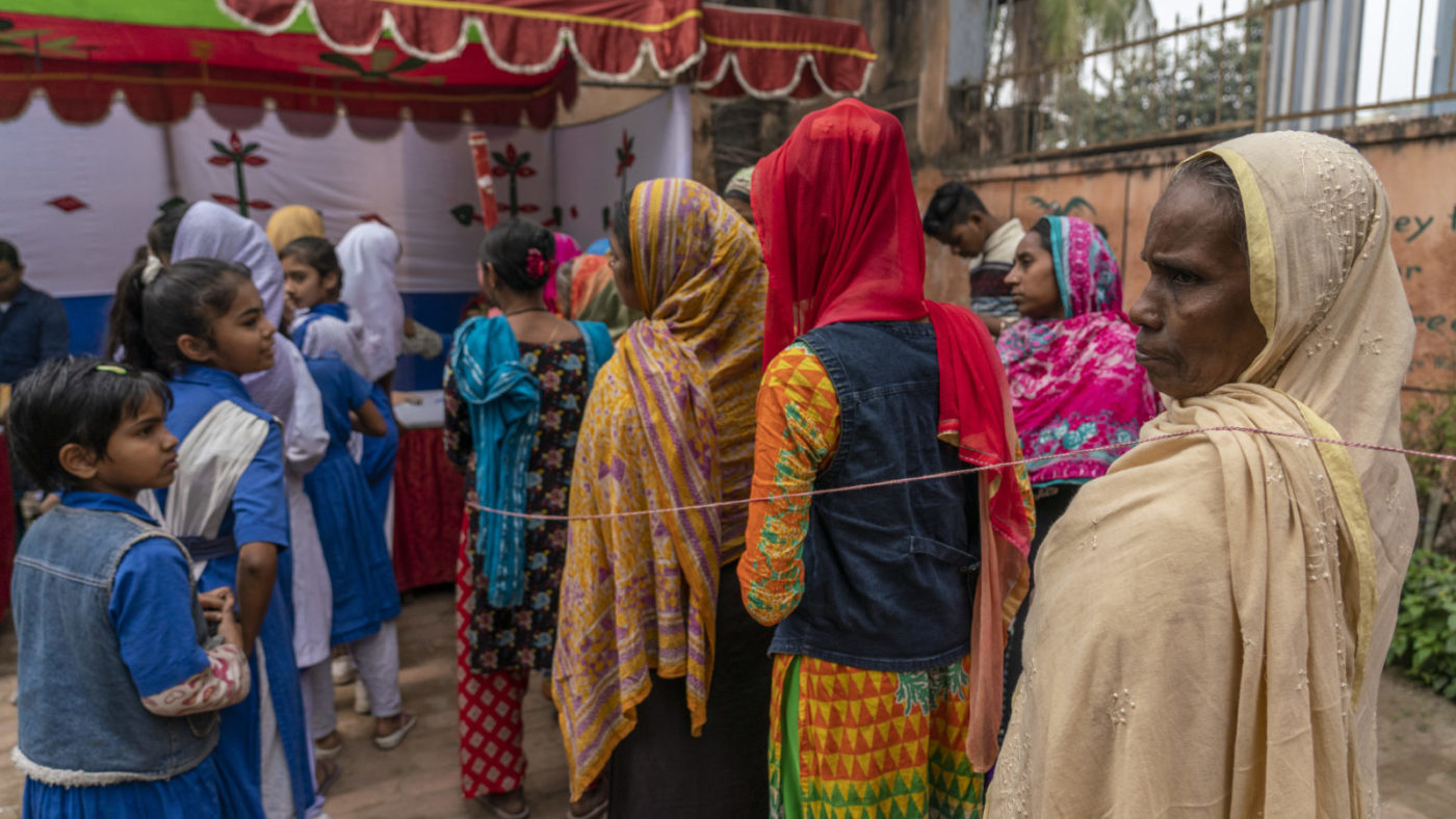 women and girls stand at the screening camp.