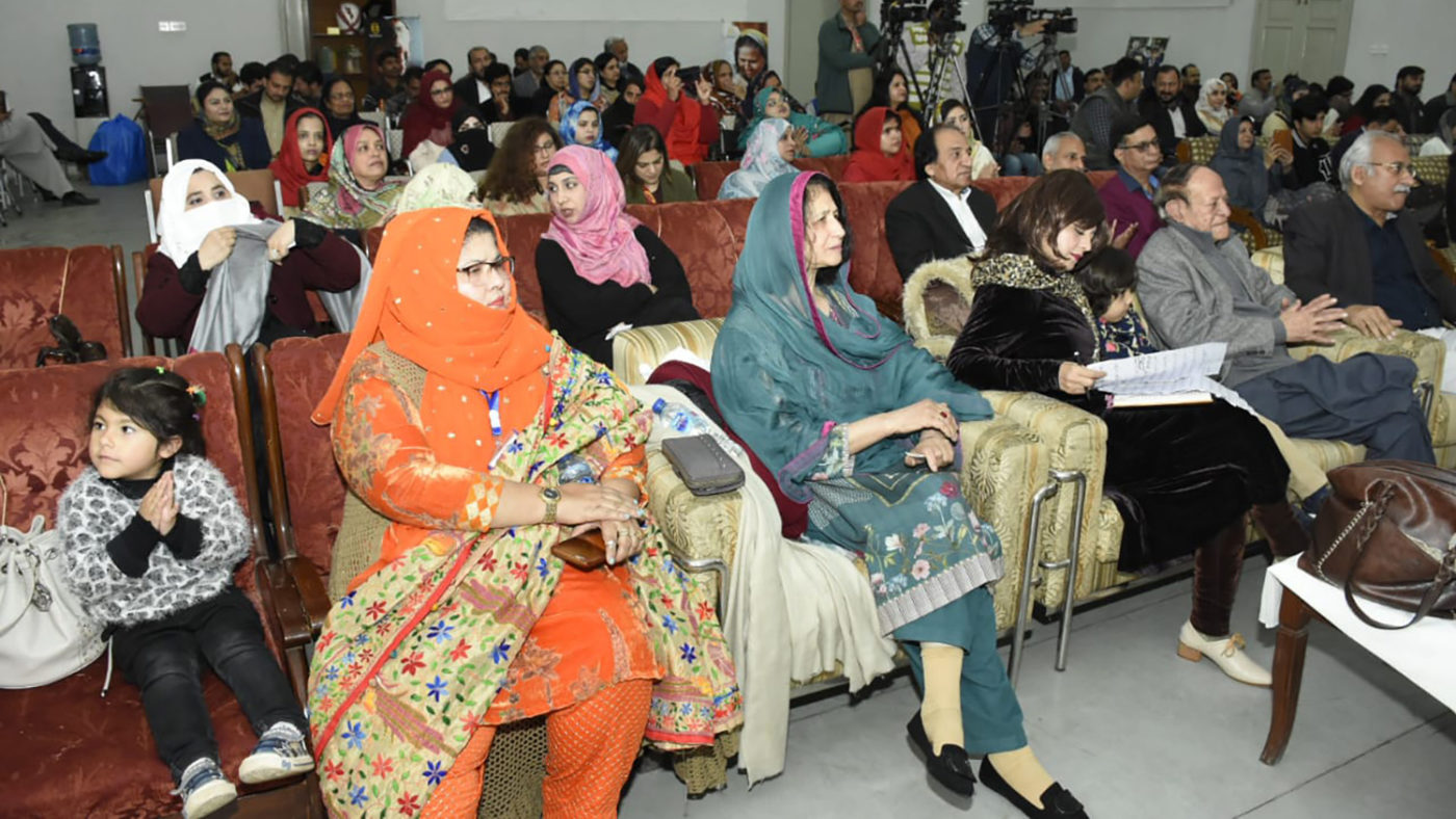 A large group of people gather in a room.