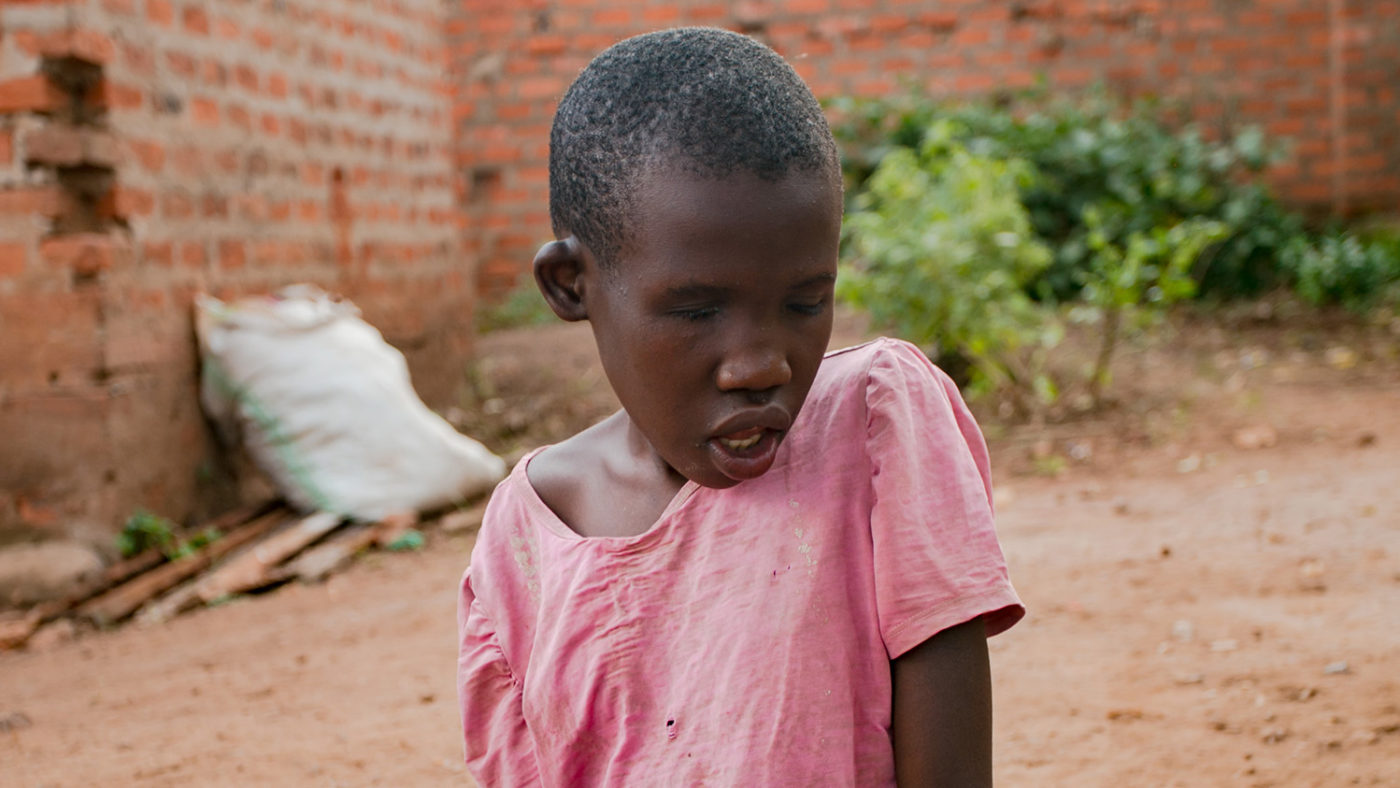 A young girl sits on the ground.