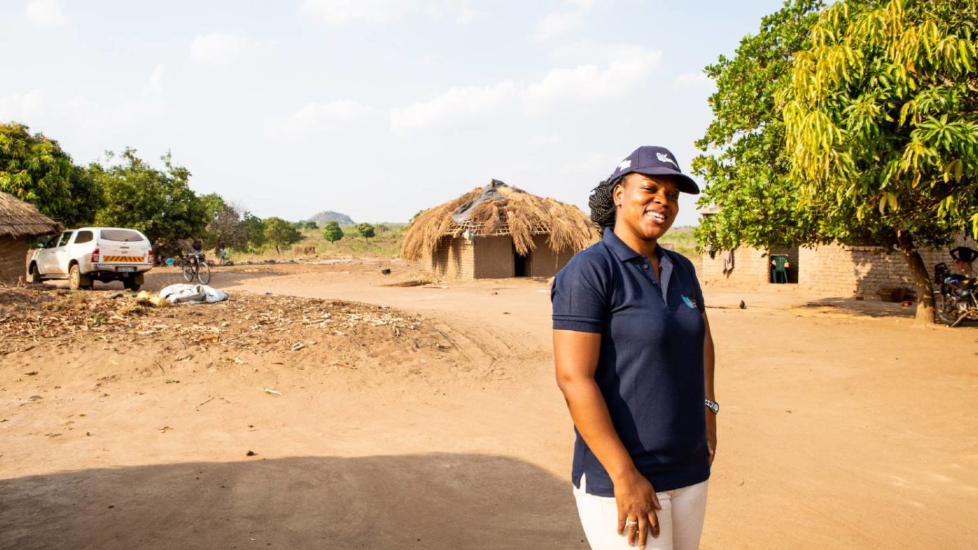 A woman stands for a portrait outside after completing surveys for river blindness in Mozambique.