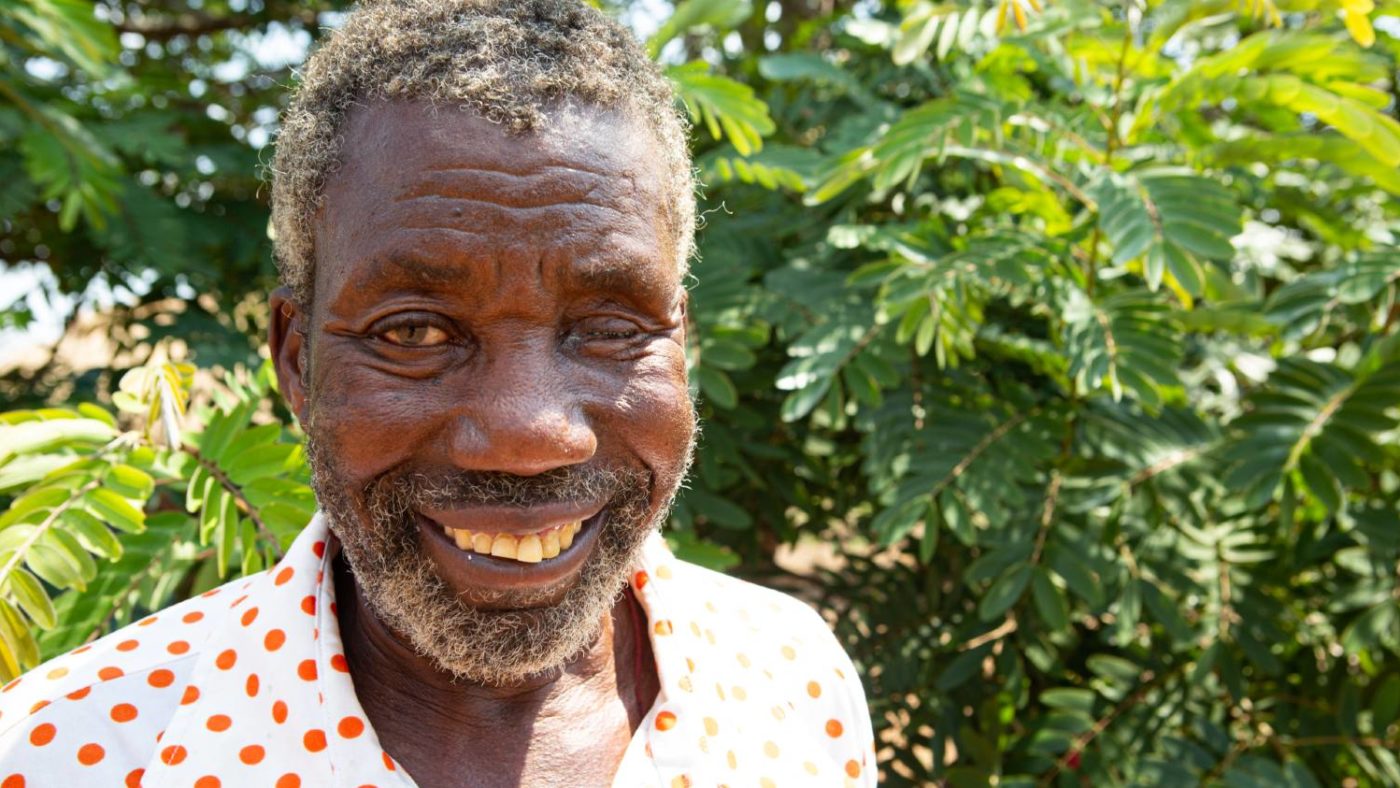 A man stands for a portrait outside.