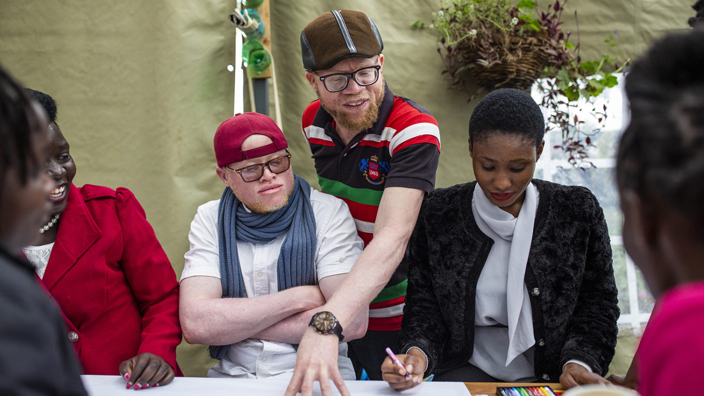 People sitting, looking at a piece of paper.