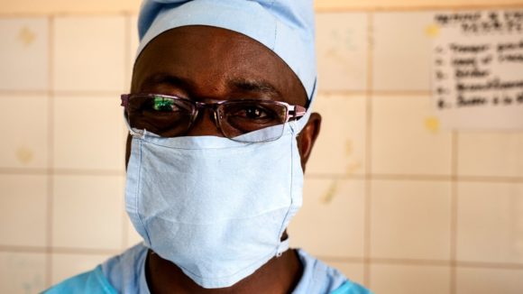 Dr Amadou wearing scrubs and a face mask.