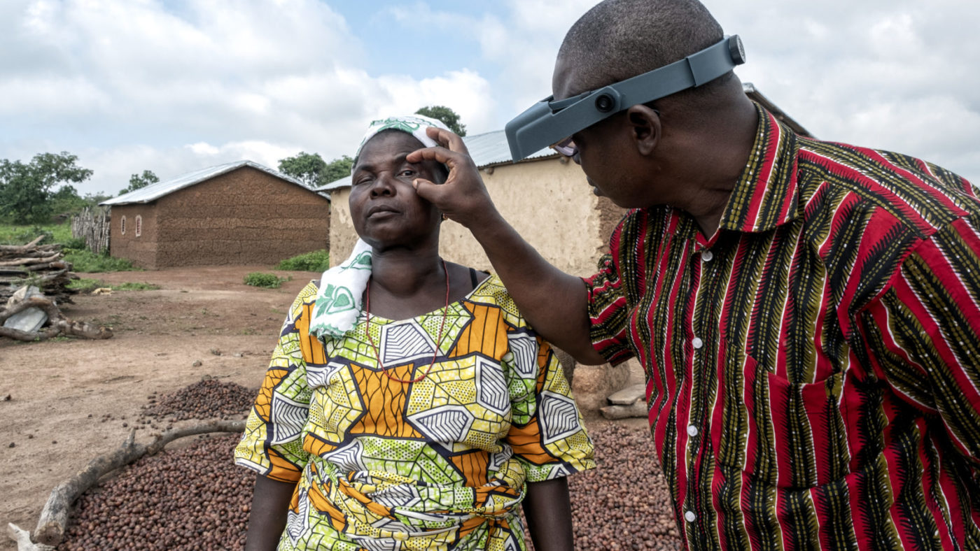 A woman has her eyes checked by a doctor.
