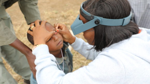 A health worker checks a boy's eyes.