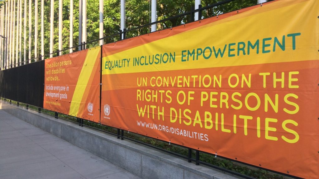 A banner on a long gate, promoting the UN Convention on the Rights of Persons with Disabilities.