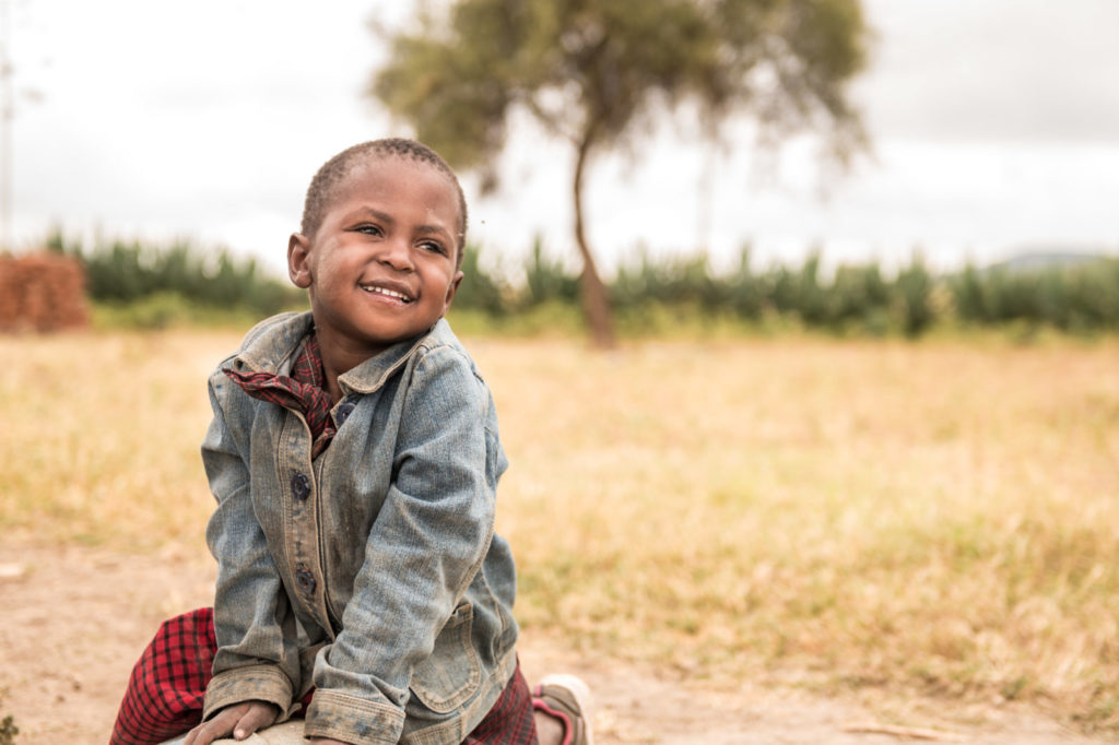 A little boy smiling outside