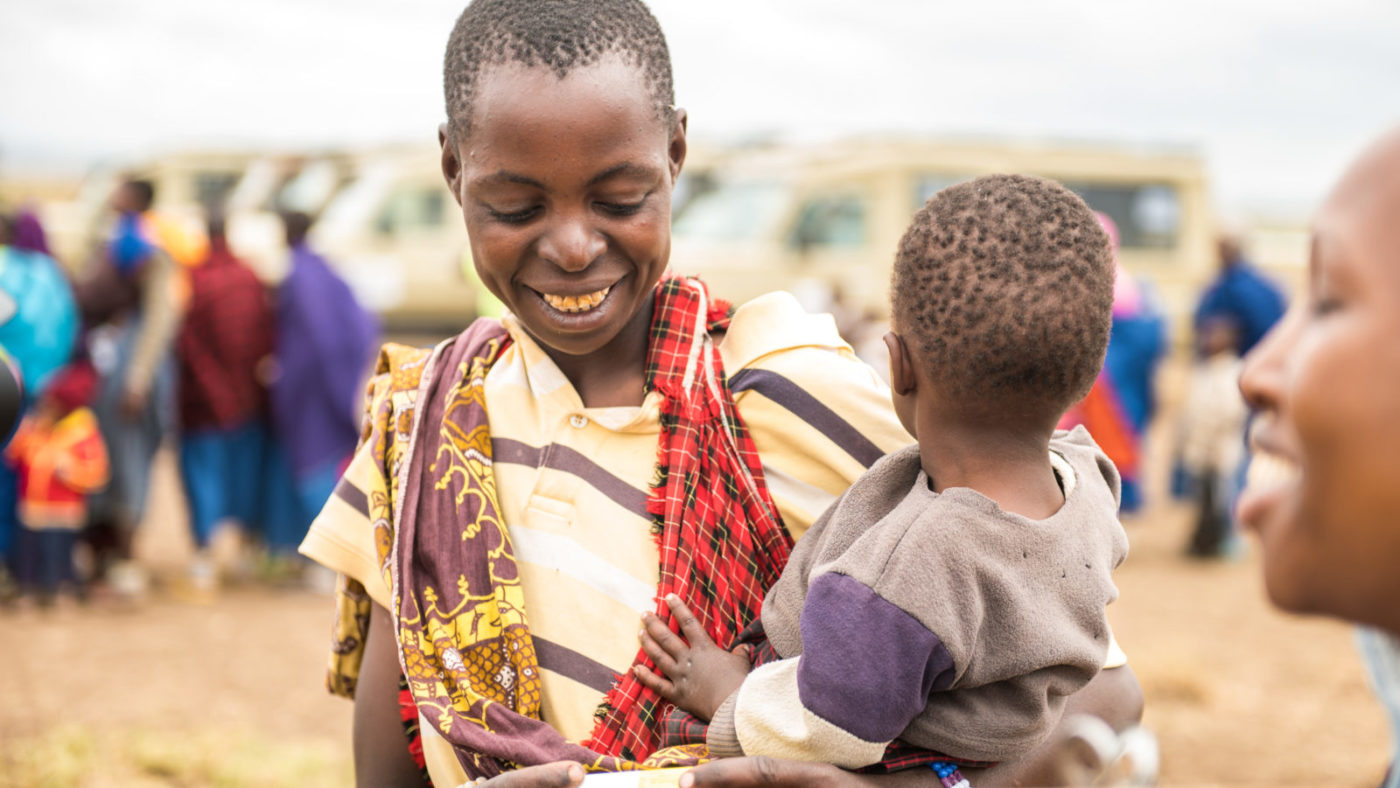 A mother holds her child, smiling.