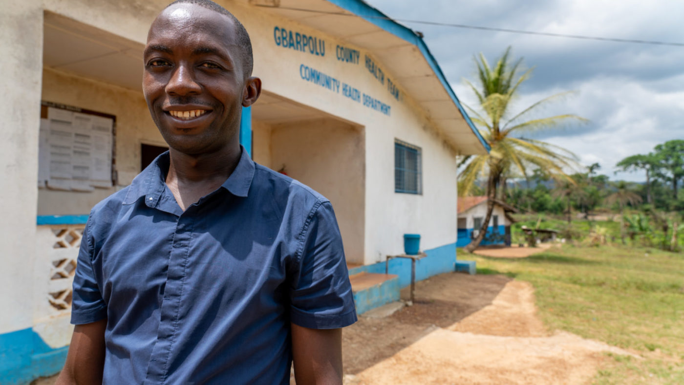 Mark, a community volunteer, stands outside smiling.