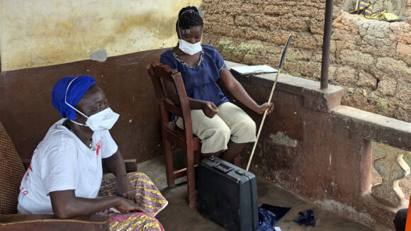 A woman sits next to a teenage girl.