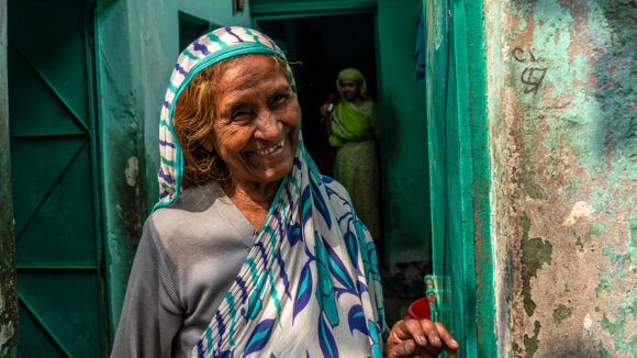 A smiling women stands in a doorway.