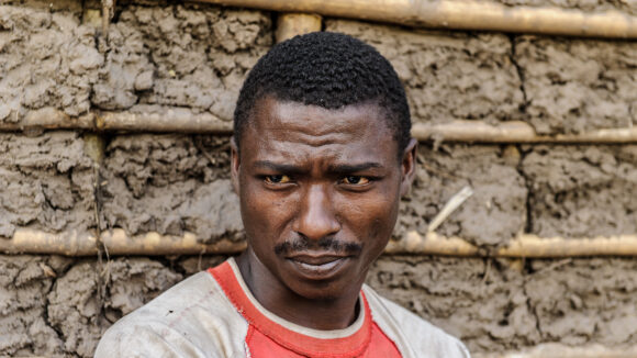 A man stands against a wall.