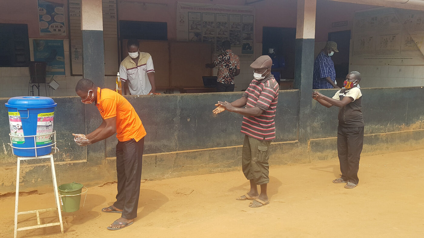Volunteers wash their hands and practice social distancing before a training.
