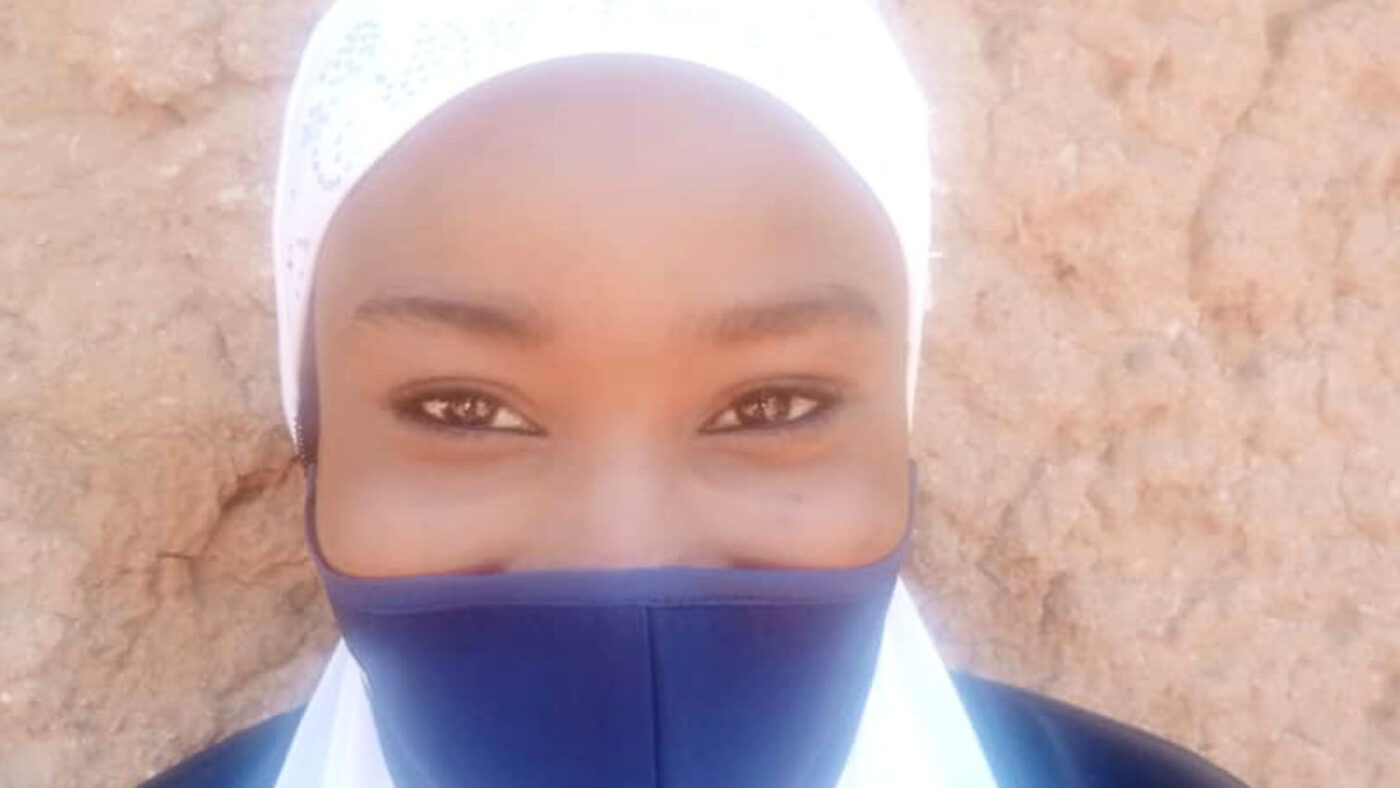 A portrait of a woman wearing a mask.