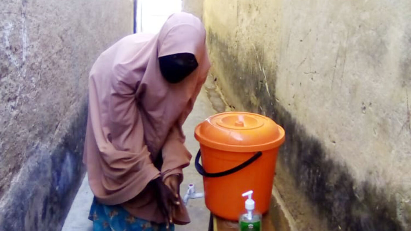 A woman washes her hands.