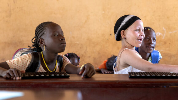 Two girls with visual impairments in a school.