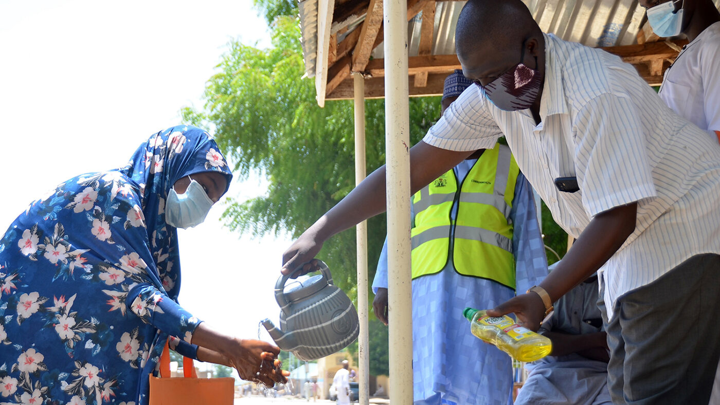 A man pours clean water for a woman to wash her hands.