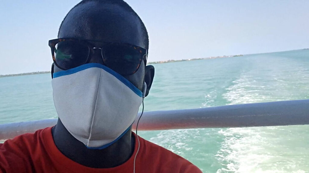Young man wearing face mask and sunglasses on boat
