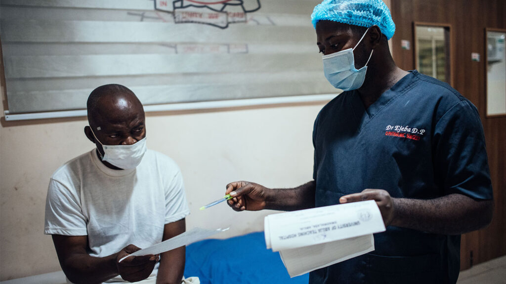 A man speaks to a health care worker in a hospital.