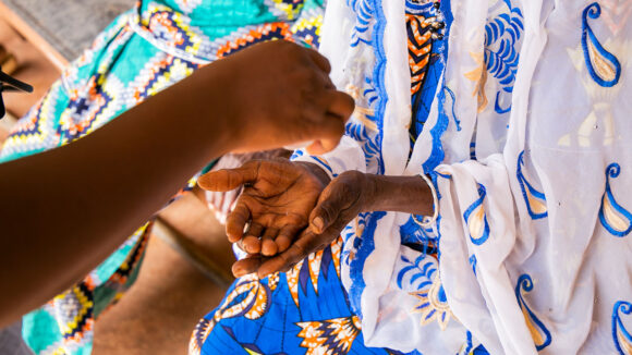 A close-up of a woman's hand being washed with gel.