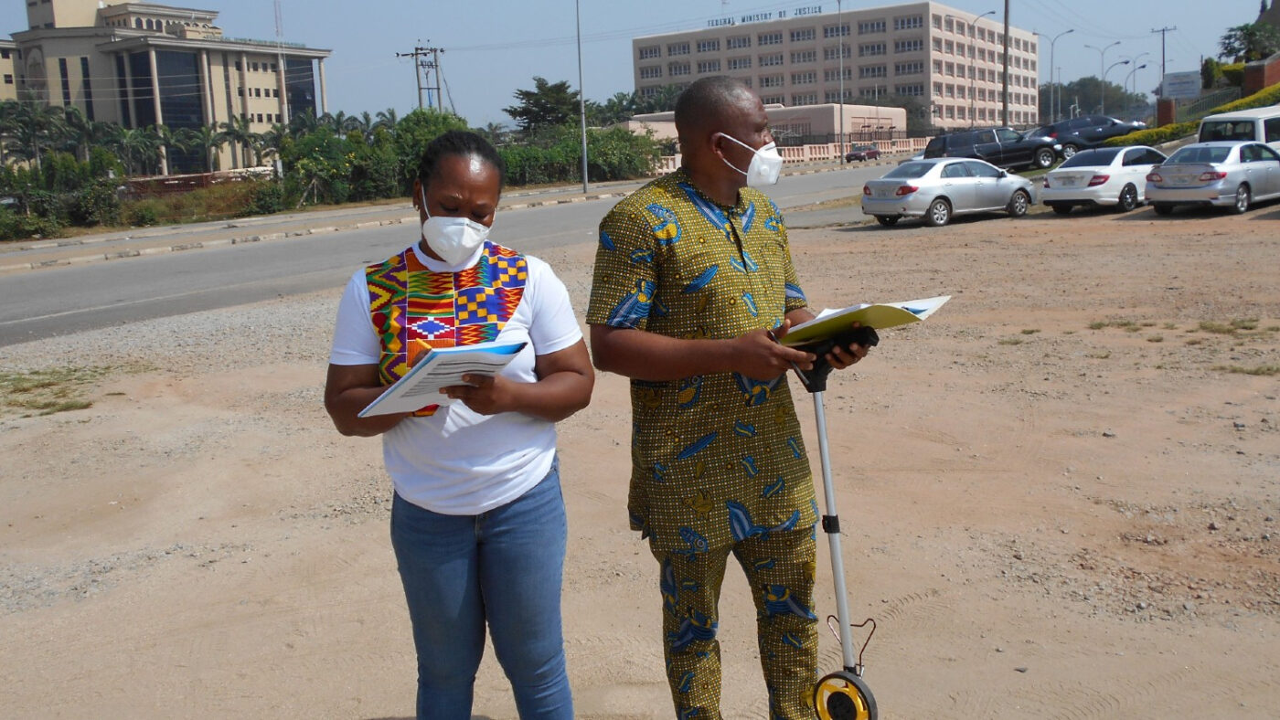 Two researchers are standing outside conducting an audit.