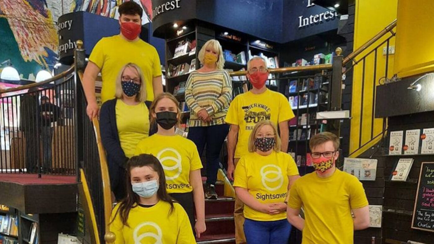 A group of people wearing yellow outfits and holding fundraising buckets