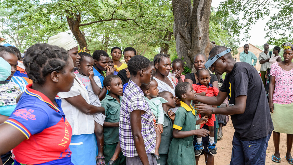 Ophthalmic nurse Jeremiah Gwafa screens community members' eyes for trachoma.
